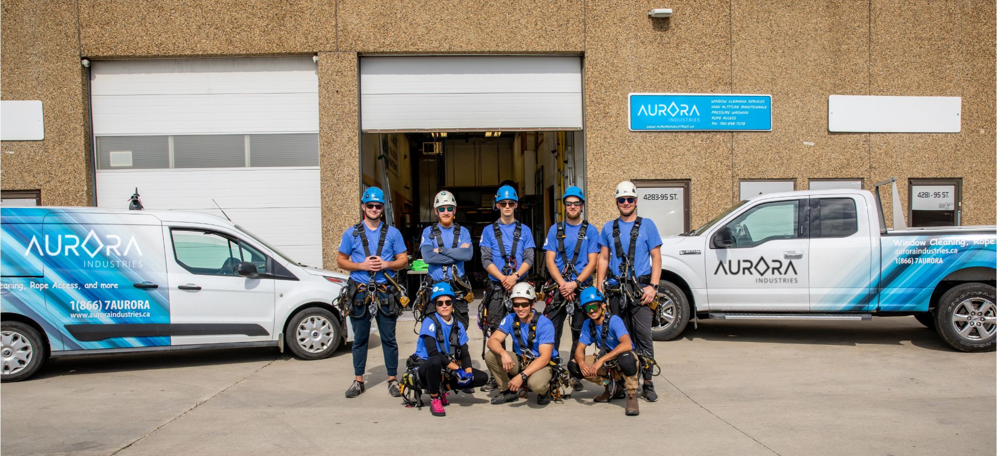 aurora industries professional team outside of their main office with two company trucks in south edmonton